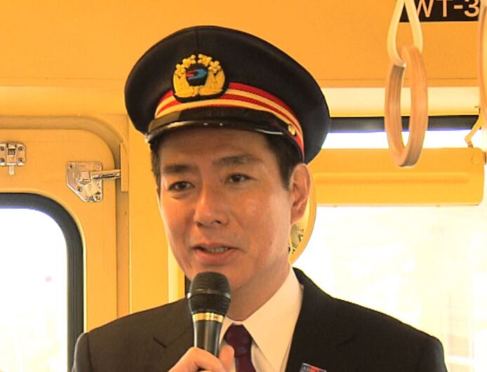 車掌の恰好をする前原誠司